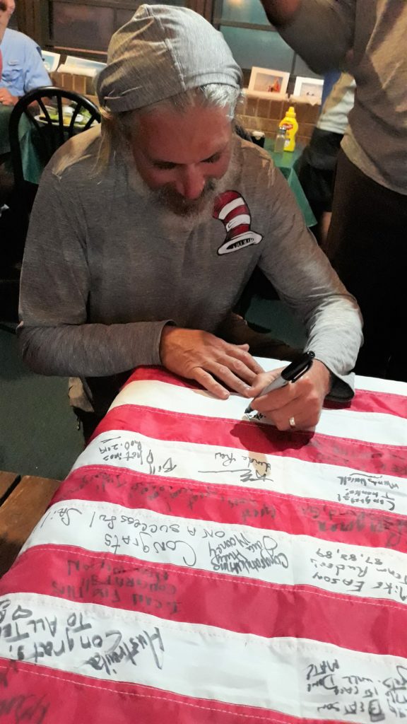 Larry Ferber signs the flag